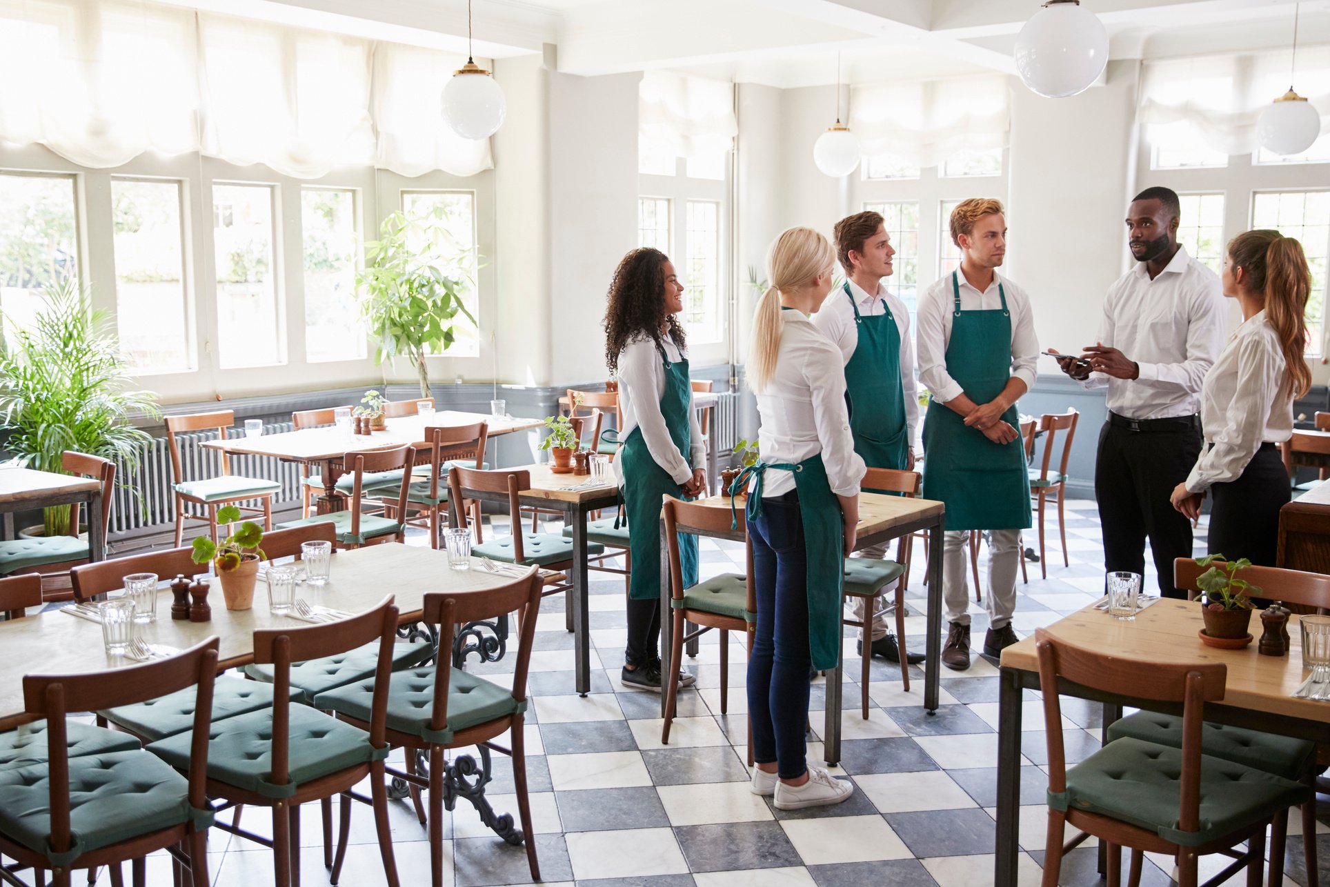 Staff Attending Team Meeting in Empty Dining Room